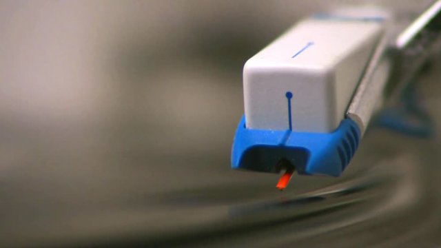 An ultra extreme close up of a turntable stylus being put on a vinyl record. HD 1080.