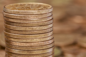 Close-up of a pile of five cents Euro coins stacked in front of heaps of coins