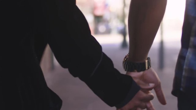 African American couple holding hands and walking, close up on their hands