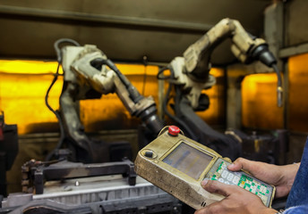 Team leader of production dept. Teaching new program to robot welding automotive part