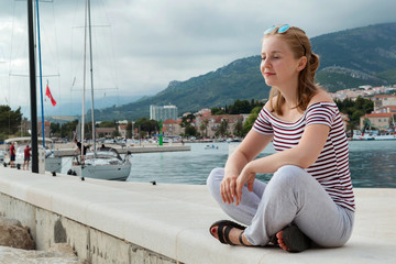 Obraz premium Girl sit meditation on the pier. Makarska riviera, Dalmatia, Croatia, Europe.