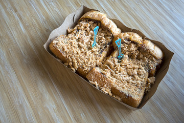 Toast with Dried shredded pork and Chili Paste  in a paper plate on the wooden table (with copy space)