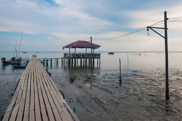 Naklejka premium The new tourist attraction wooden bench and beuatiful sky on the wood bridge at Pattani in Thailand