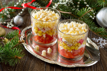 Christmas salad with tomatoes, corn and crackers on a wooden tab