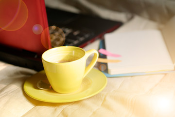 coffee cup with laptop and notebook and Calculator on bed ,  wor