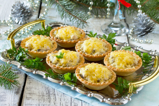 Tartlets with mushrooms, mushrooms, chicken and cheese on a Chri