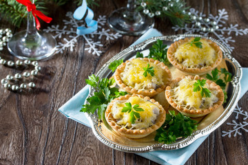 Fototapeta na wymiar Holiday appetizer: tartlets with mushrooms and meat on a celebra