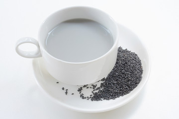 Soya milk and black sesame seeds in cup on white background © mayura_ben