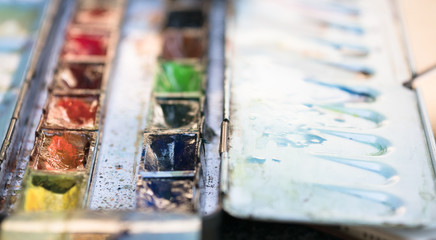 opened tray of watercolor with stain and water drop