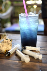 Iced blue soda with colorful syringes