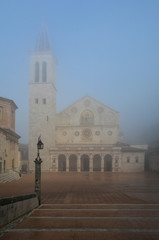 Fototapeta na wymiar Spoleto (Italy) - A misty fall day in the charming medieval village in Umbria region. The soft focus depends on dense fog, which, however, creates an evocative atmosphere with Sun rays 