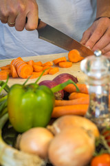 Chef slicing fresh carrots for a salad