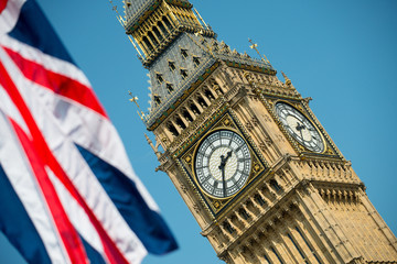 Obraz na płótnie Canvas Union Jack flag and Big Ben against a clear blue sky