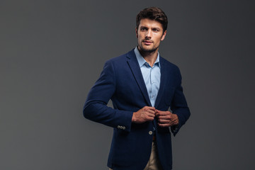 Confident businessman putting on blue jacket