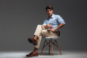 Relaxed handsome man in blue shirt sitting on the chair