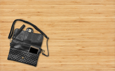 luxury leather black bag or wallet with smart phone on top view