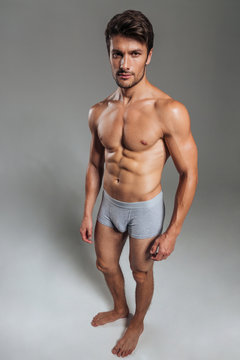 Portrait of a serious handsome muscular man in underwear standing