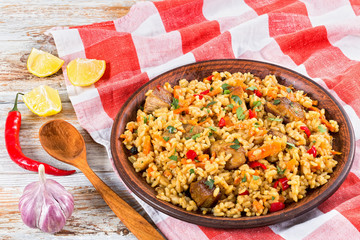 rice with meat, pepper, vegetables and spices on clay dish