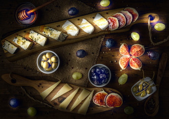 platter of italian cheeses with figs, olives, grapes and honey 
