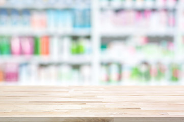 Empty wood table top on blur pharmacy shelf background