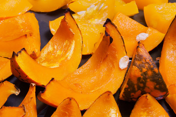 Piece of baked vivid orange colour pumpkin on the baking sheet