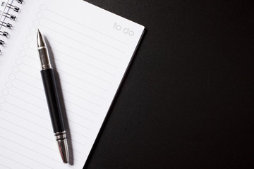 to do list and pen on black background
