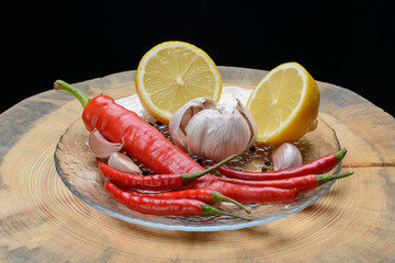 Red chilli papper, garlic and lemon on wood texture background