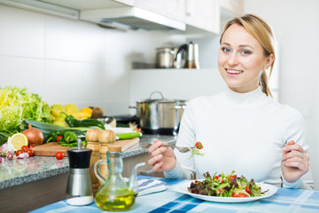 Naklejka premium Cheerful blond girl eating salad