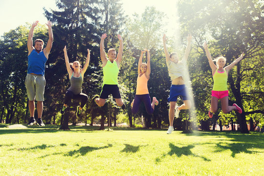 group of happy friends jumping high outdoors