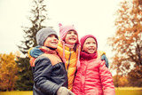 group of happy children hugging in autumn park