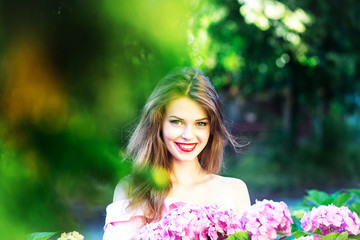 Fototapeta premium pretty smiling girl in hydrangea flowers