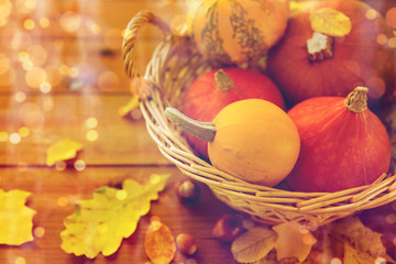 close up of pumpkins in basket on wooden table