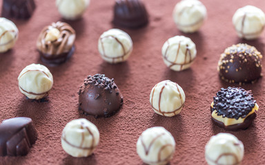 Chocolate candies on cocoa background