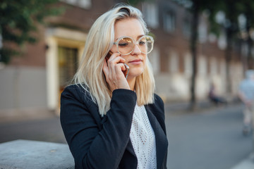 Obraz na płótnie Canvas Business woman is talking by the phone. City background.