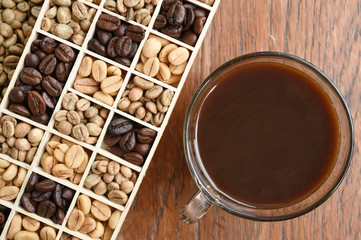 Cup of coffee and coffee beans on wooden background
