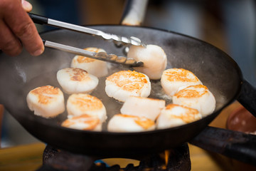 close up of scallops frying in cast iron pan