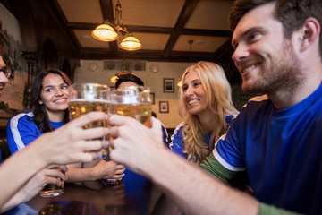 football fans clinking beer glasses at sport bar