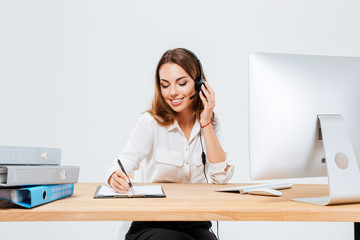 Woman making notes while talking with custumer on the phone