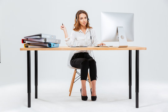 Happy young woman working with computer in call center