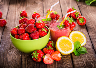 Strawberry on wood background. Strawberry with green leaves.