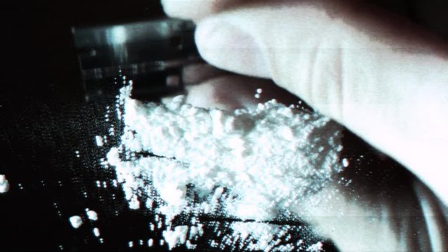 A security cam styled video of a person crushing cocaine.