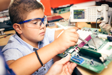 Little boy and teacher in class with electronic project