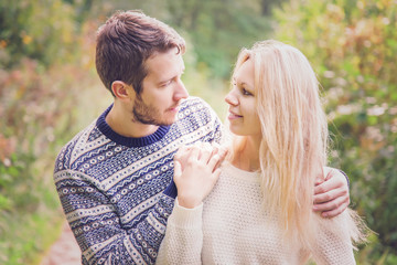 Young man and woman look at each other and resting in the park.