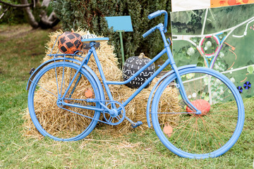 Fototapeta premium Blue bicycle with hay and pumkpins decoration, ar harvest festival in Moldova