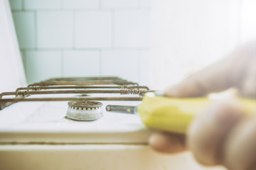 hand ignites the gas burner, using a lighter in the kitchen in the morning