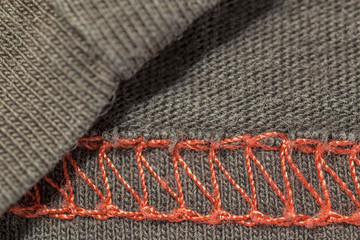 closeup macro red overlock seam on a brown T-shirt fabric