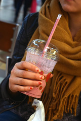 Young woman holding a raspberry smoothie.