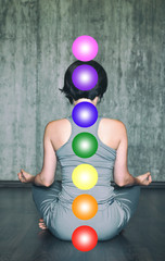 Woman practicing meditation with the chakras. Beautiful young woman doing yoga meditation in lotus...