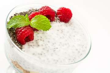 Chia yogurt with raspberries in a glass cup isolated

