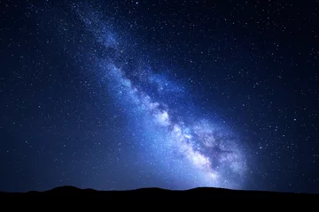 Foto op Aluminium Melkweg. Nacht kleurrijk landschap met sterren. Sterrenhemel met heuvels in de zomer. Ruimteachtergrond met melkweg bij bergen. Natuur achtergrond met blauwe melkweg. Universum © den-belitsky